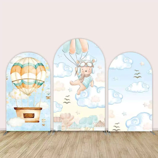 Adorable sky adventure-themed backdrop set with a teddy bear, hot air balloons, and clouds, perfect for a baby shower or young child’s birthday.