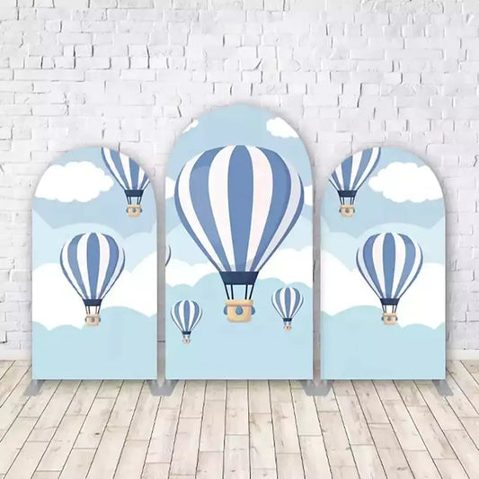 Set of three hot air balloon-themed arched backdrops with vintage hot air balloons floating in a blue sky with white clouds, perfect for adventure and travel-themed birthday parties.