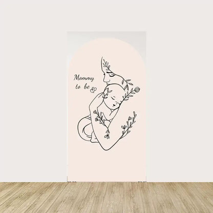 Arch panel with line art of a mom holding a sleeping baby, decorated with floral accents and “Mommy to be” text.