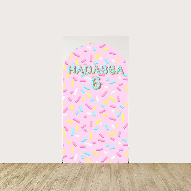 Pink background with scattered colorful sprinkles and the text "Hadassa 6" for a personalized birthday touch.