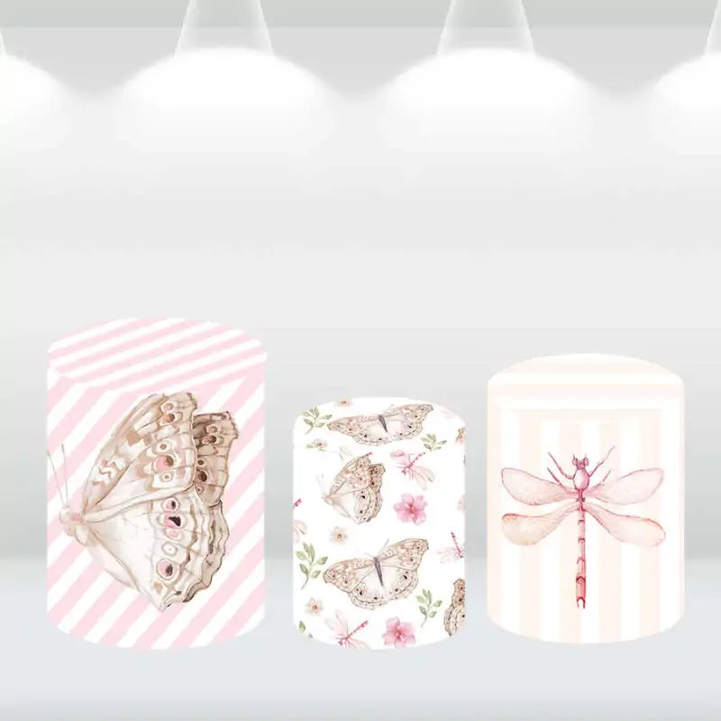 Three cylindrical covers featuring pink-striped patterns and butterfly and dragonfly illustrations, perfect for complementing floral-themed events.