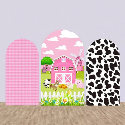 Three-panel pink farm-themed arch backdrop with gingham pattern, barnyard animals in front of a pink barn, and cow print on the side.