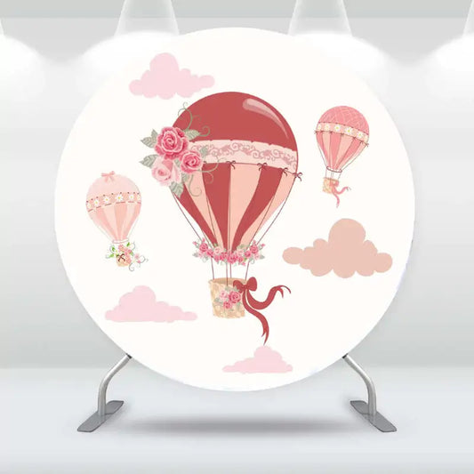 Pink hot air balloon baby shower backdrop with floral details and pastel clouds.