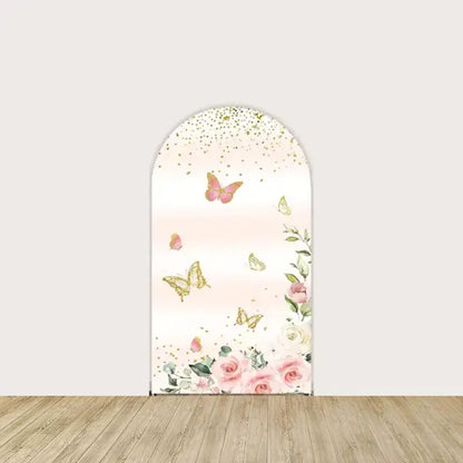 Blush pink backdrop adorned with gold glitter, butterflies, and floral details, creating a whimsical, celebratory feel.