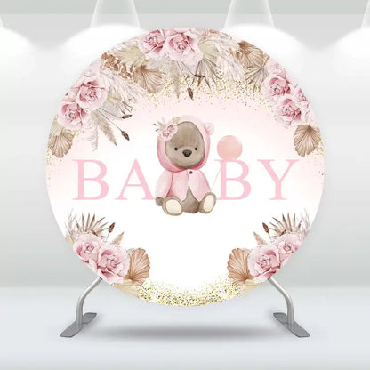 Round baby shower backdrop with cute teddy bear in pink outfit, soft blush flowers, gold glitter accents, and ‘BABY’ text – perfect for baby girl celebrations