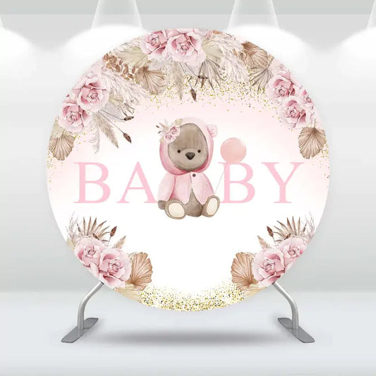 Round baby shower backdrop with cute teddy bear in pink outfit, soft blush flowers, gold glitter accents, and ‘BABY’ text – perfect for baby girl celebrations