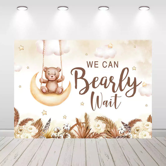 Teddy bear sitting on a moon baby shower backdrop with neutral colors.