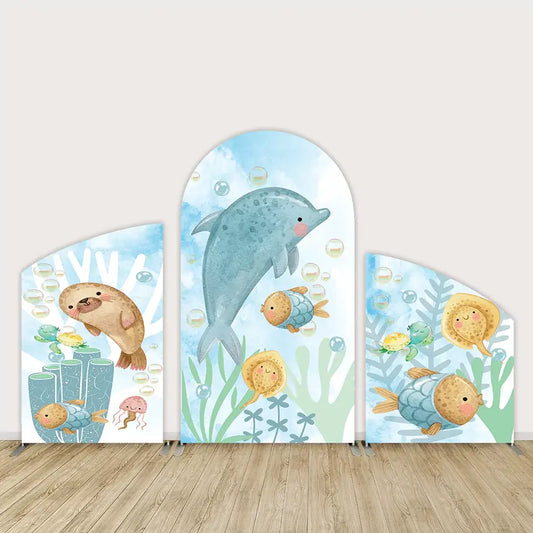 Three-panel ocean-themed arch backdrop set with dolphin, seal, turtles, fish, jellyfish, coral, and bubbles—ideal for under-the-sea birthday or baby shower decor.