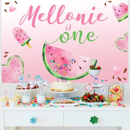 Pink backdrop for Mellonie's first birthday featuring watermelon slices, ice pop illustrations, and 'Mellonie is One' in stylish fonts.