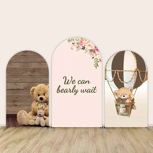 3-piece arch backdrop for baby shower featuring teddy bears, “We Can Bearly Wait” text with florals, and bear in a hot air balloon—neutral theme with wood accents.