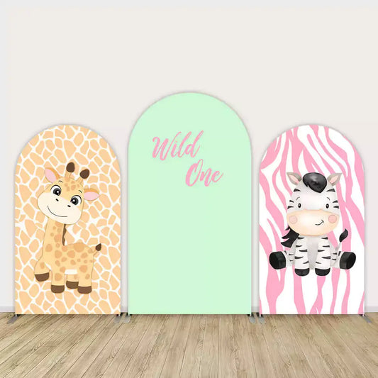 Three-panel Wild One safari birthday backdrop featuring cute cartoon giraffe, smiling zebra, and mint green panel with pink “Wild One” text.